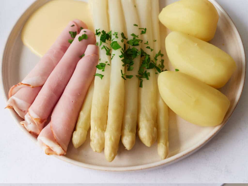 german white asparagus with ham sauce hollandaise potatoes 4 3 Traditional German Creamy White Asparagus Soup Recipe German White Asparagus, Parsley, Potatoes, Ham and Sauce Hollondaise